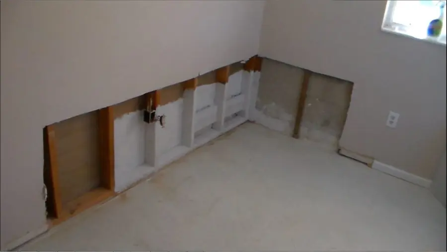 Lower drywall cut away so the wall cavities can dry, a standard step in a Monroe dry-out