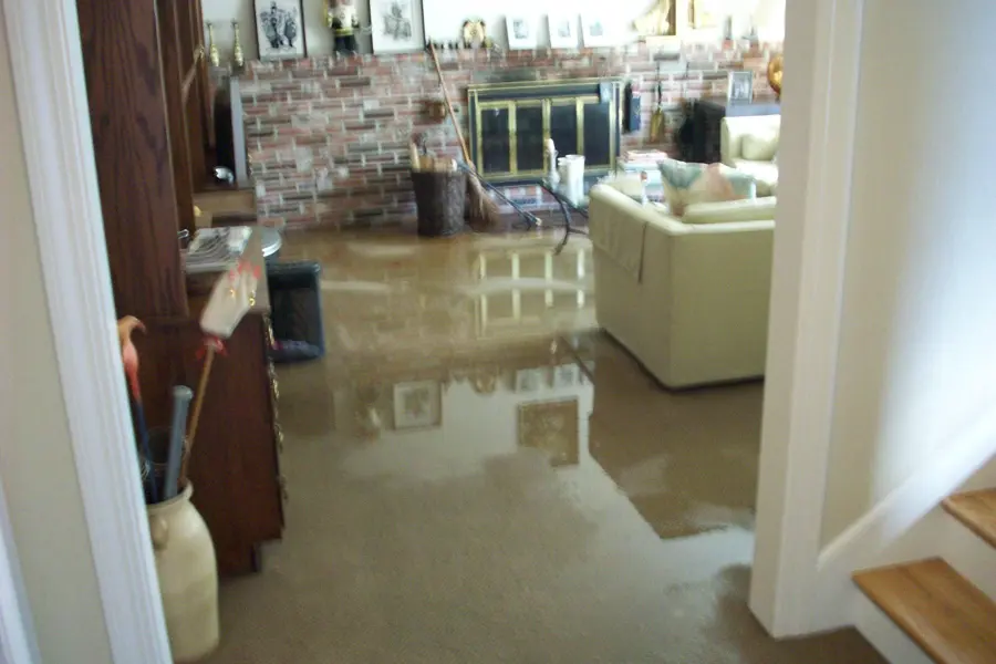 Family room with a brick fireplace and standing water across the floor