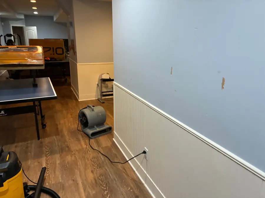 Monroe water damage restoration: an air mover drying the walls of a finished basement rec room