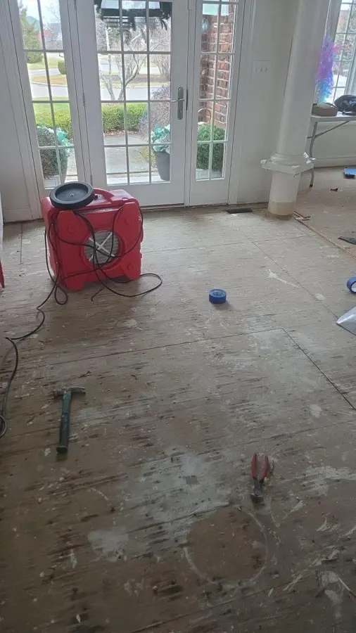 Oregon local water damage conditions: a red air mover drying a bright room after the flooring was removed