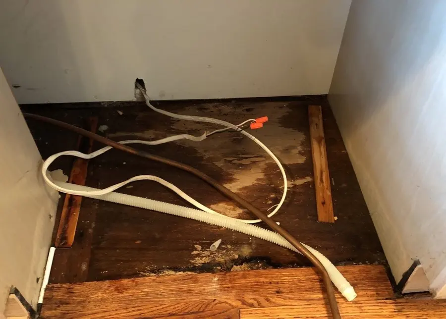 Monroe washer and dishwasher leak cleanup: a dishwasher bay opened to a stained, wet subfloor