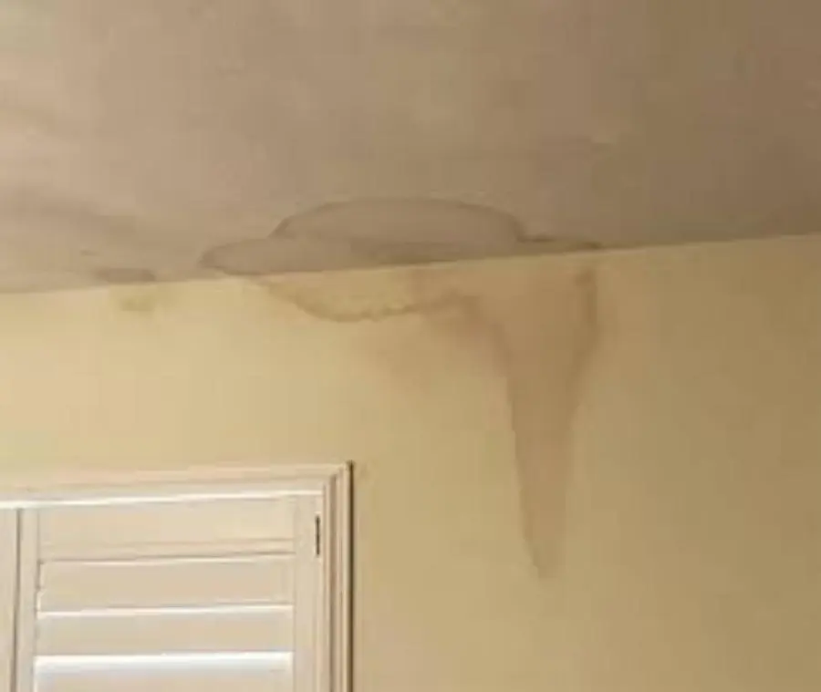 Monroe ceiling leak water damage: a water stain spreading across a ceiling and down a wall